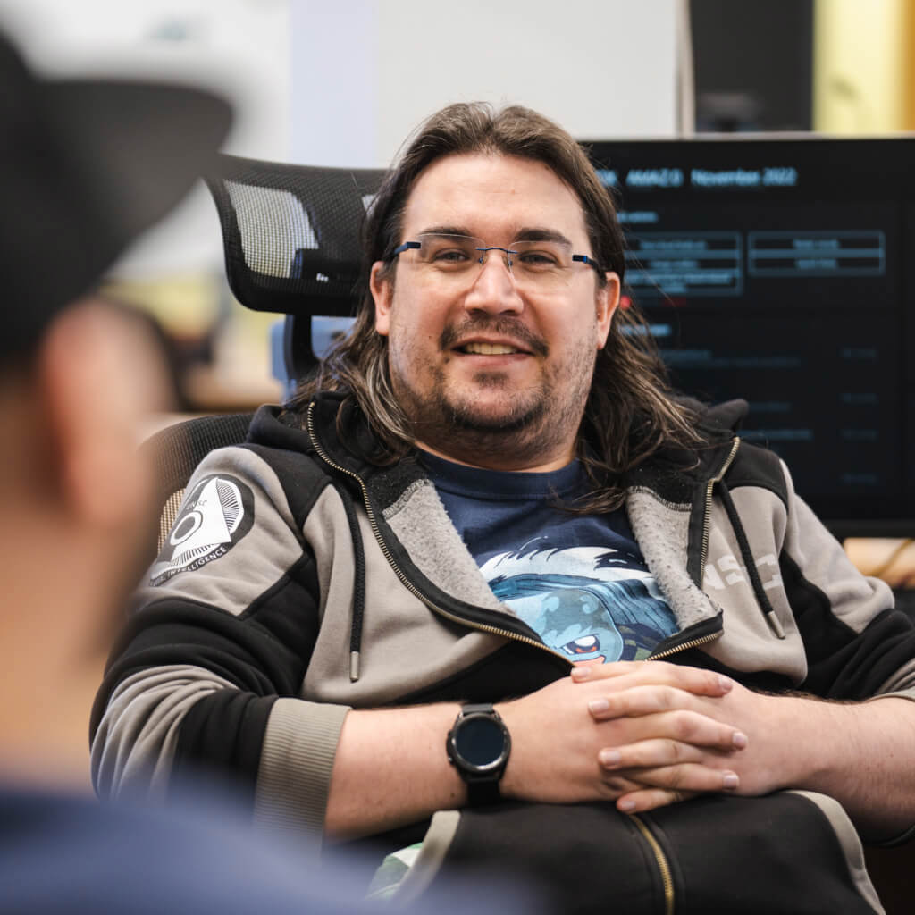 Photo of a Stainless Games team member sitting back at their desk